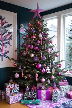 A beautifully decorated Christmas tree with purple ornaments and candy canes stands beside a pile of colorful wrapped gifts in a festive room.