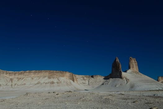 Night scene with the rock pinnacles of Bozzhira valley, Kazakhstan. Ursa major constellation