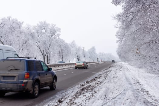 winter interstate road with snow covered trees at overcast day.