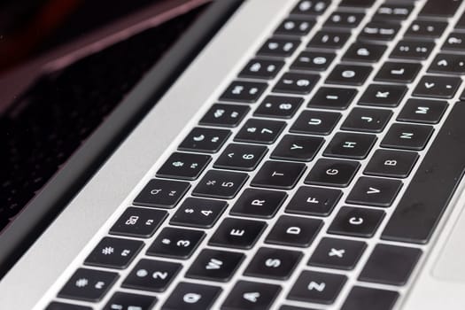 keyboard of famous silver colored laptop with fingerprints, closeup