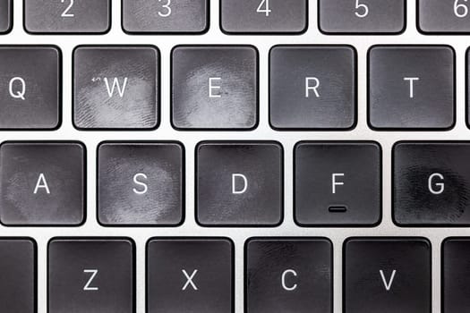 keyboard of famous silver colored laptop with fingerprints, closeup