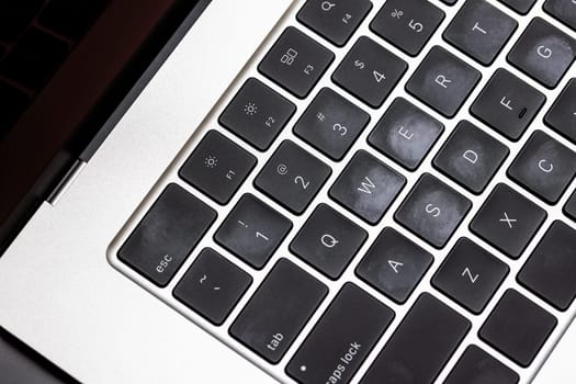 keyboard of famous silver colored laptop with fingerprints, closeup