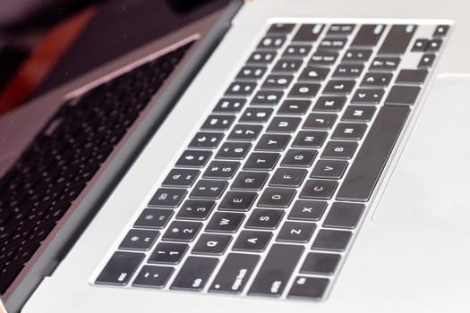 keyboard of famous silver colored laptop with fingerprints, closeup