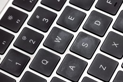 keyboard of famous silver colored laptop with fingerprints, closeup
