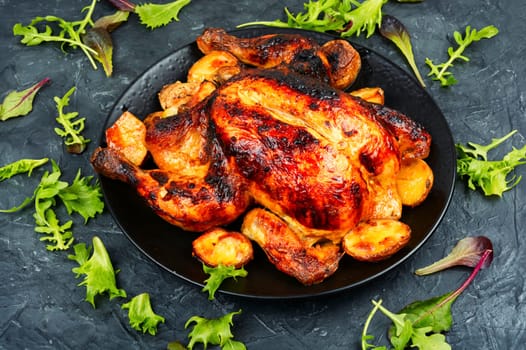Delicious baked chicken with apples is appetizing served on a ceramic dish. Copy space. Menu, recipe place