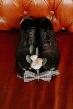 These stylish black formal shoes are beautifully adorned with vibrant flowers and a charming bow tie accent
