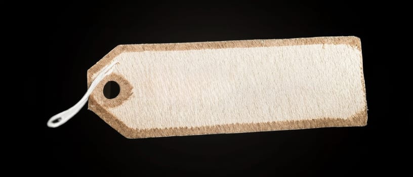 A blank wooden tag on a black background, ideal for adding personalized text or labels with ample copy space.