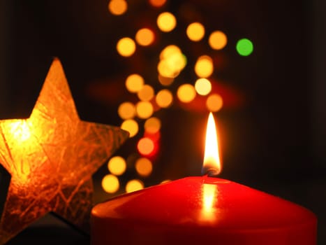 Burning Advent candle with blurred Christmas lights, beautiful romantic Christmas background
