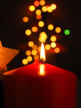 Burning Advent candle with blurred Christmas lights, beautiful romantic Christmas background
