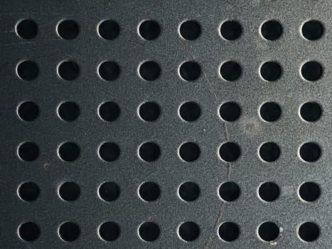 Anthracite steel or metal plate with dots or holes using as industrial background or header