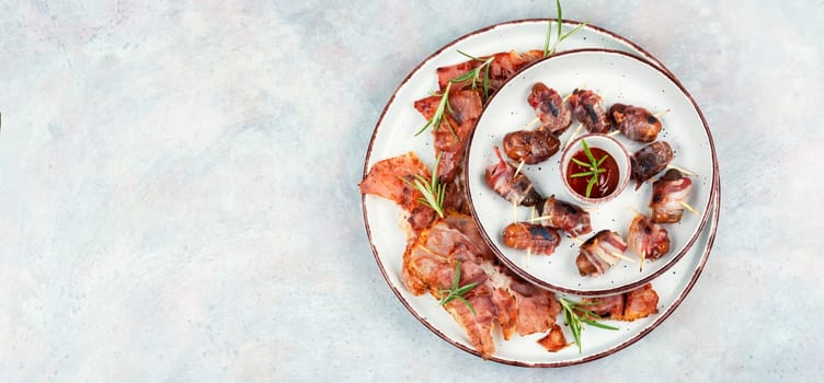 Homemade sweet and savory bacon wrapped dates served on a platter. Rustic style.