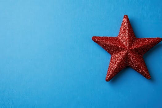 A bright and glittering red Christmas star is elegantly placed on a solid blue backdrop. This festive decoration adds a cheerful touch, perfect for celebrating the holiday spirit.