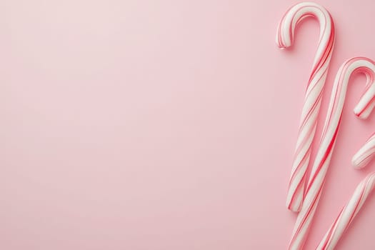 Festively colored candy canes rest elegantly on a smooth pastel background, embodying the spirit of the holiday season. Their vibrant red and white stripes add a cheerful touch to any decor.