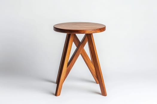 This chic side table showcases a simple yet elegant design with a round wooden top and crossed legs. It stands alone in the center, highlighting its versatility and modern appeal.