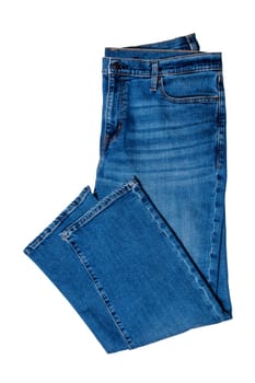 Jeans isolated. Folded trendy stylish blue denim stretch pants or trousers for men isolated on a white background. Clipping path. Jeans summer and autumn fashion.Jeans isolated. Folded trendy stylish blue denim stretch pants or trousers for men isolated on a white background. Clipping path. Jeans summer and autumn fashion.