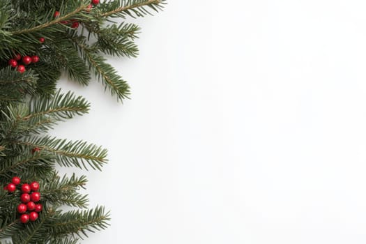 Lush pine branches adorned with vibrant red berries are arranged neatly on a crisp white background evoking a festive atmosphere.