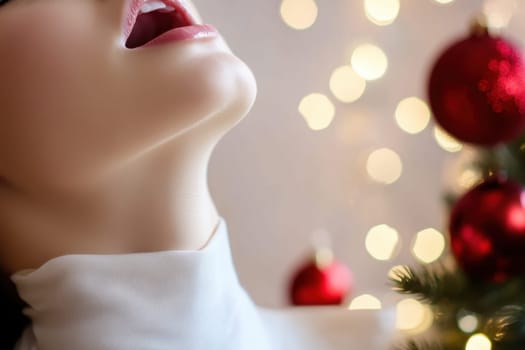 A woman with a joyful expression sings near a decorated Christmas tree adorned with bright lights and red ornaments during the holiday season.