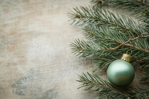 A green ornament rests on fresh pine branches creating a festive atmosphere perfect for winter celebrations and holiday decorations.