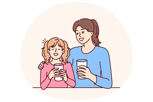 Mom and daughter drink natural milk to get useful vitamins and lactose or calcium from eco product. Woman hugging smiling teenage girl drinking milk to promote healthy food without chemicals