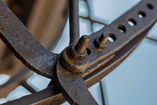 Rusty bolt fastening metal parts, showcasing intricate welding details. Aged bolt adds character to weathered metal, creating grungy texture telling a story of time