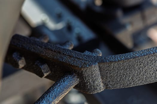 Metal rivets securely join two pieces of metal, creating a strong connection with a grungy, weathered look. Background shows industrial machinery in a factory setting
