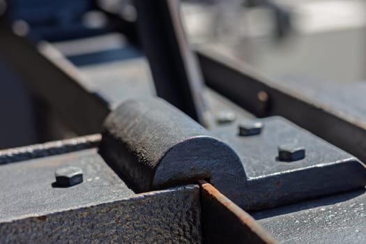 Close up of a metal hinge showing the details of welding and joining of traditional metal parts, highlighting the craftsmanship and durability of the structure