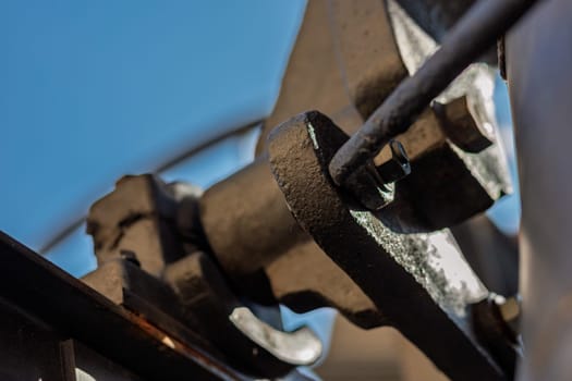 Close up of an old church bell mechanism, highlighting the craftsmanship and intricate details of welding and joining traditional metal parts