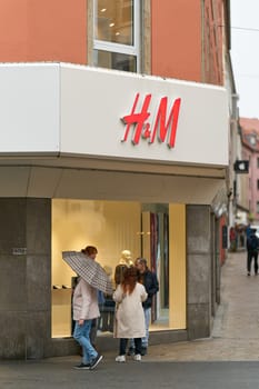 Passers-by window-shopping in front of a store in the city center of Würzburg