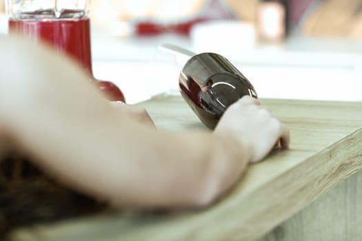 Young woman lies unconscious on a kitchen counter, reaching for spilled wine, conveying sadness and despair. Alone, she needs help with alcoholism
