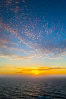 Dramatic sunset blue sky with clouds over the pacific ocean, vertical shot