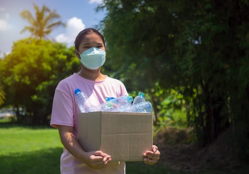 Recycle concept, woman collecting garbage and holding a recycle bin with plastic bottles in the outdoors, Plastic-free, Junk food plastic packaging, Reduction environmental pollution.
