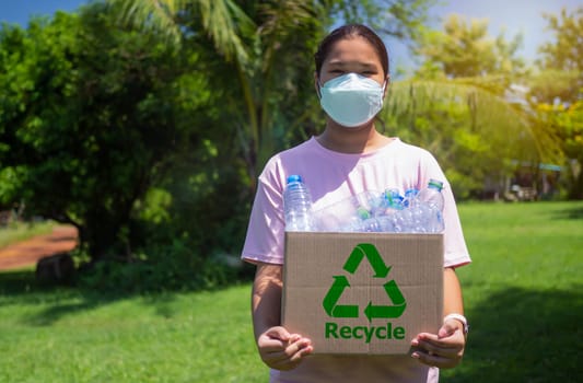 Woman collecting garbage and holding a recycle bin with plastic bottles in the outdoors, Recycle concept, Plastic-free, Junk food plastic packaging, Reduction environmental pollution.