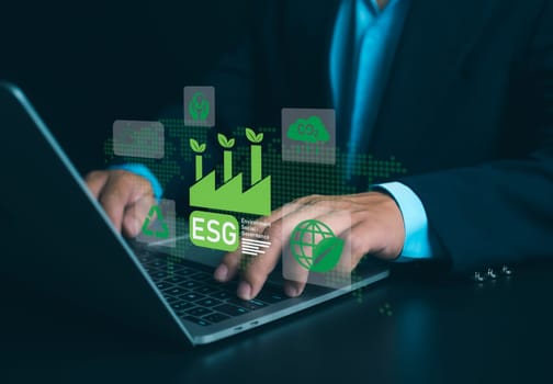 Businessman using laptops to analyze ESG on screen in business investment strategy concept, ESG environment social governance investment business concept, Environmental and business growth together.