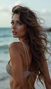 A brunette woman in a swimsuit gazes back while standing near the shoreline. Gentle sea waves lap at her feet under a clear blue sky. Long hair, beautiful young face. Travel and clothing adverts. AI.