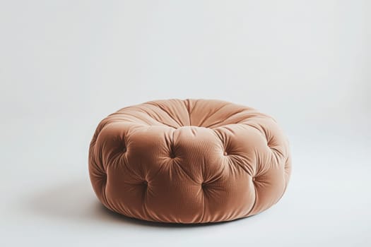 A soft, plush ottoman sits alone at the center of a minimalistic room, offering a warm touch and comfort to the inviting atmosphere. Its tufted design adds an elegant flair to the decor.