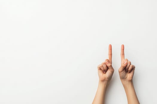 Two hands are raised, fingers crossed in a hopeful gesture. The clean, solid white background creates a minimalist aesthetic, emphasizing the symbol of luck or aspiration.