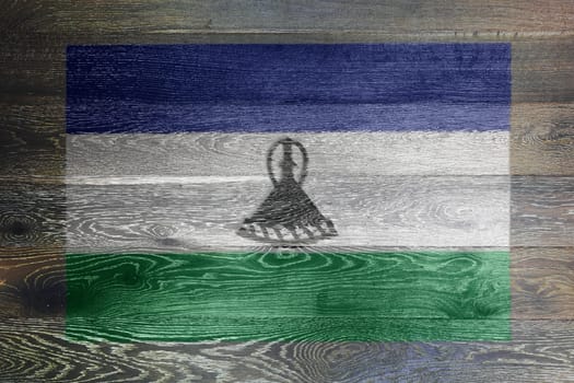 A Lesotho flag on rustic old wood surface background