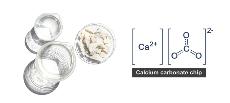 Calcium carbonate chip in chemical watch glass with molecular structure place next to beaker on white laboratory table. Top view