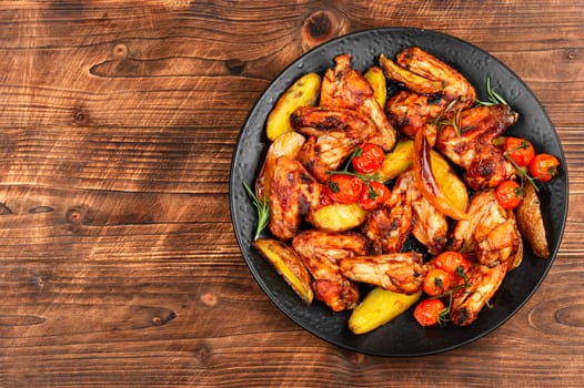 Roasted chicken wings and baked potatoes. BBQ.