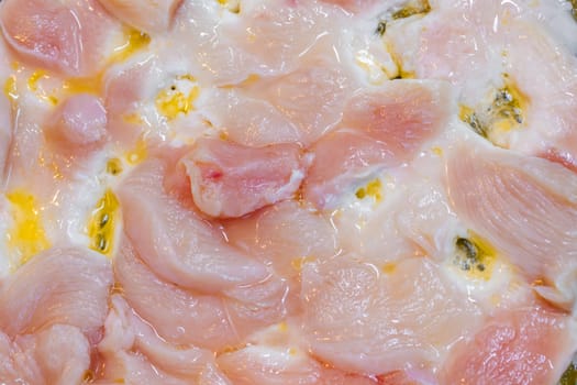closeup full-frame background of raw chicken breast meat just starting to roast.
