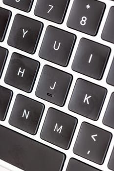 keyboard of famous silver colored laptop with fingerprints, closeup
