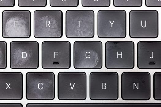 keyboard of famous silver colored laptop with fingerprints, closeup