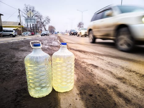 cars passing by plastic bottles with gasoline on the side of the road with, the concept of street cheaper Kazakh gasoline vendors reselling in Bishkek, Kyrgyzstan