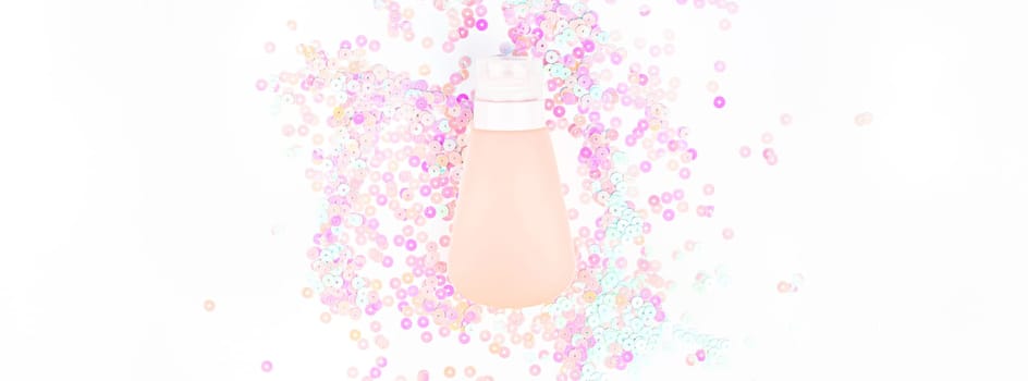 Cosmetic cream lotion tube on white pearl pastel confetti sparkles background with copy space. Creative conceptual top view flat lay backdrop for your beauty blog text design