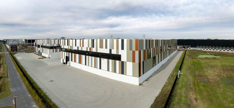ALMELO, NETHERLANDS - OCTOBER 12, 2024: Aerial view of some enormous  newly built modern warehouse exterior