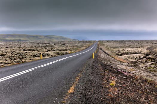 Highway through Iceland landscape at overcast day. Horizontal shot