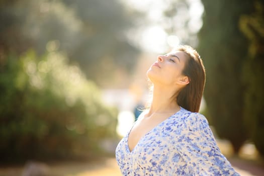 Woman breathing fresh air in a park standing alone