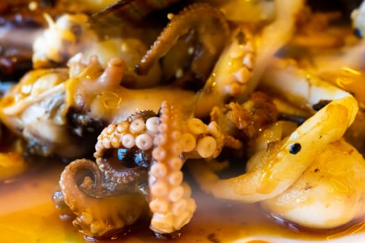 Grilled octopus closeup with an another seafood with herbs and spices. Top view