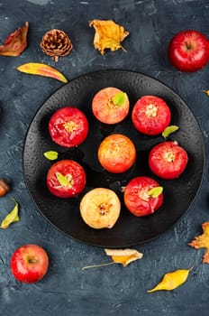 Tasty baked apples with nuts on a plate. Rustic style.