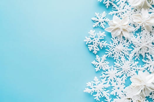 A collection of delicate white snowflakes arranged on a smooth blue surface creates a festive winter atmosphere. This decorative display is perfect for seasonal events and celebrations.